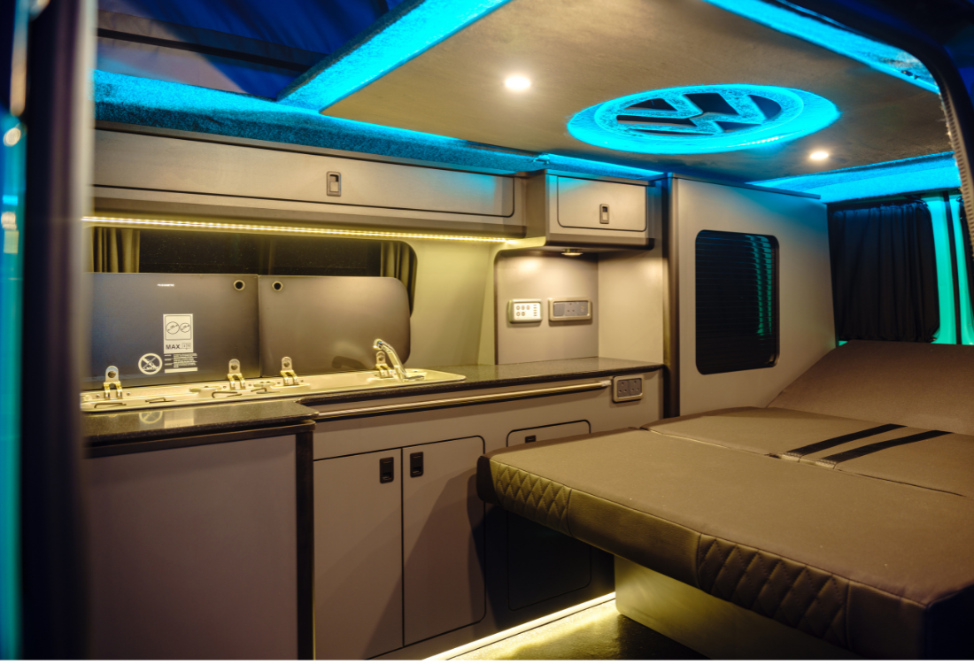 Compact campervan kitchen pod with hob, sink, and storage.